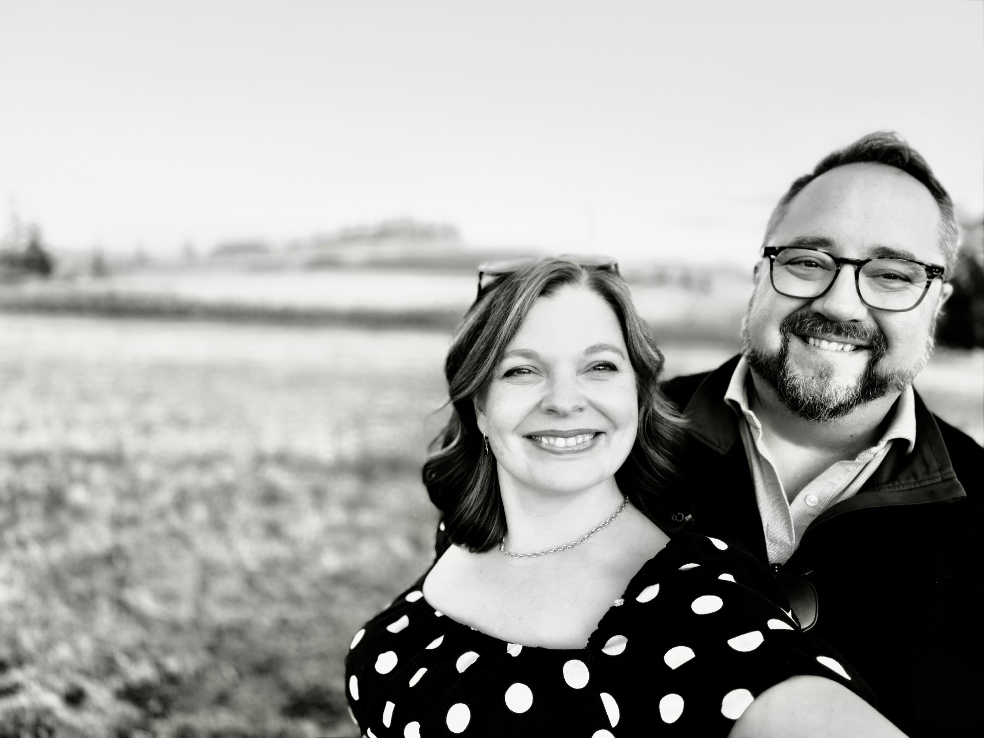 The founders of Take the Trip together in a Willamette Valley field at golden hour, in black and white